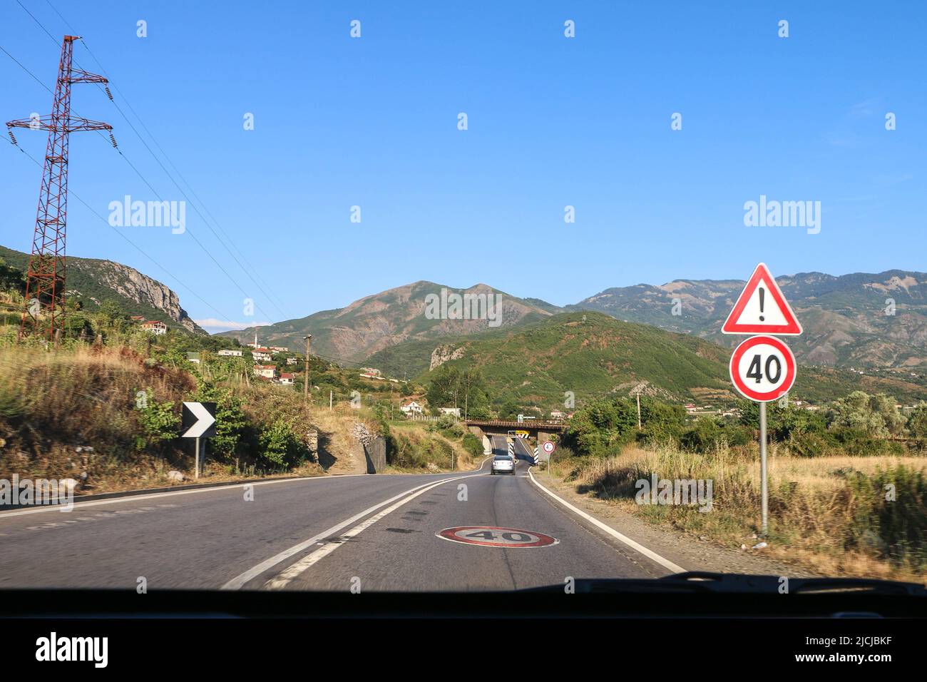 Albanien - 15.07.2017: Typische Intercity-Straße in Albanien mit Geschwindigkeitsbegrenzung 40 Zeichen, Warnschild, doppelte weiße Linien, aus dem fahrenden Auto gefangen Stockfoto