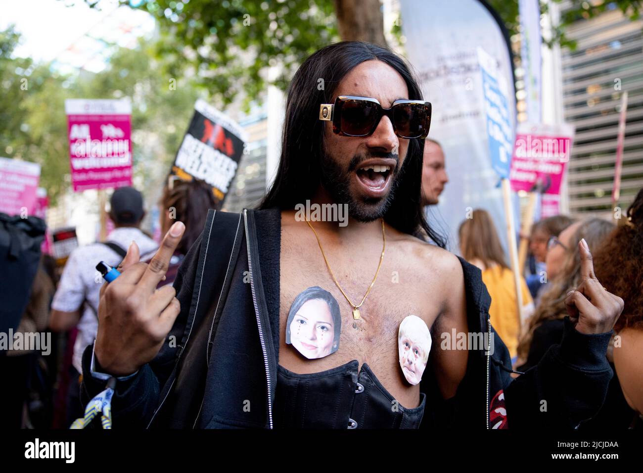 London, Großbritannien. 13.. Juni 2022. Ein Protestler klebt das Bild von Priti Patel und Boris Johnson als eine Form des Protests im Innenministerium auf seine Brust. Mehrere hundert Demonstranten demonstrieren vor dem Innenministerium, um sich gegen die Offshore-Abschiebepläne der britischen Regierung zur Abschiebung von Asylsuchenden nach Ruanda zu wehren. Die Berufung gegen die Entscheidung des Hohen Gerichts ist heute Morgen gescheitert und der erste Abschiebeflug ist für den 14.. Juni 2022 mit 8 Personen geplant, darunter Nationalitäten aus Iranern, Irakern, Albanern und Syrern. (Foto von Hesther Ng/SOPA Images/Sipa USA) Quelle: SIPA USA/Alamy Live News Stockfoto