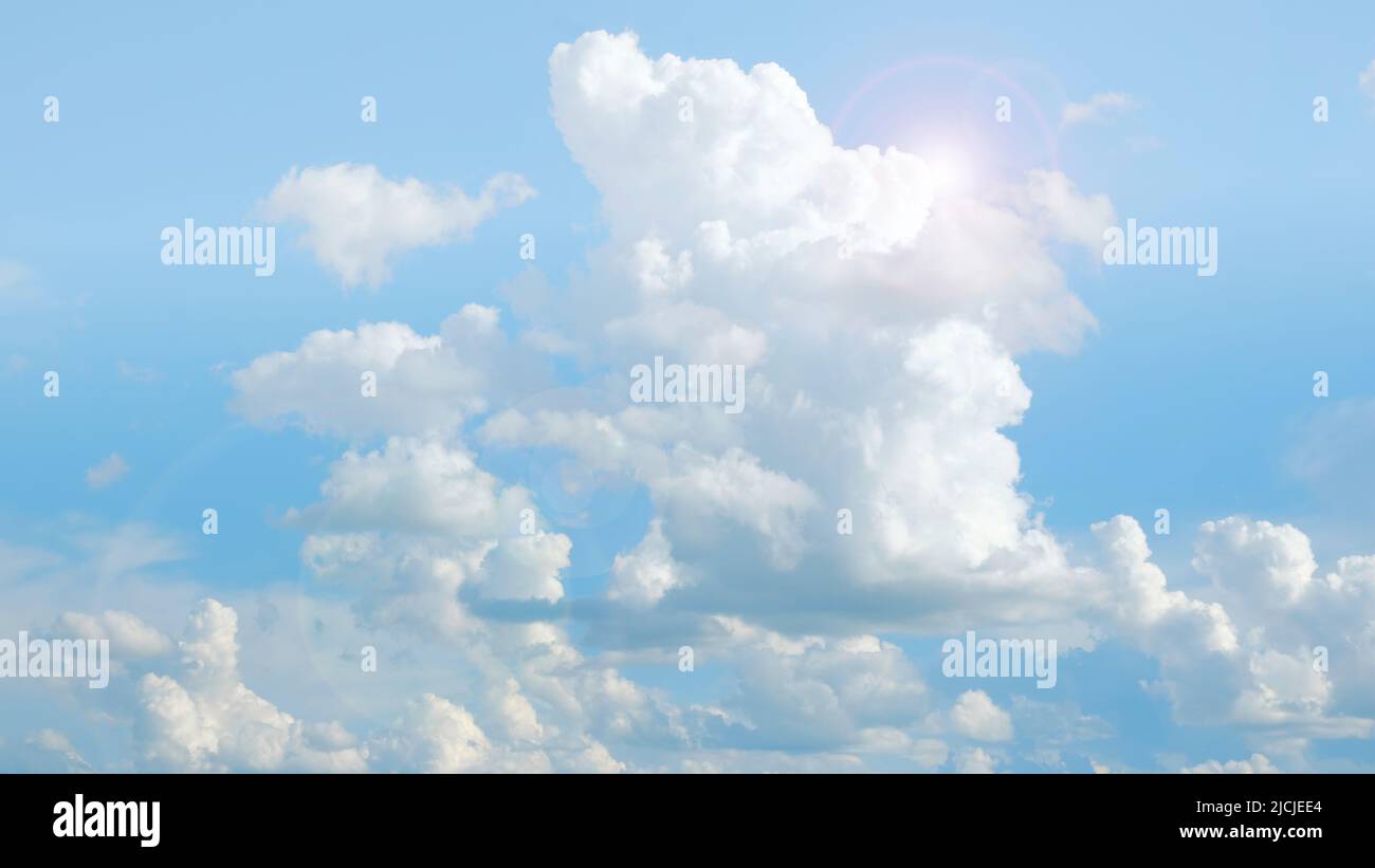 Wolken und Sonnenschein. Weiße Wolken und Sonnenstrahlen in einem blauen Himmel.schöne himmlische Tapete in Blautönen.Himmel ist in sehr hellen Pastellfarben. Himmlisch Stockfoto