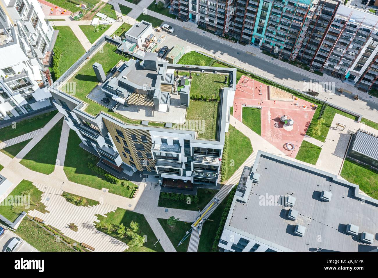 Mehrstöckige Wohnhäuser mit grünem Rasen auf Dächern. Luftaufnahme von oben. Stockfoto