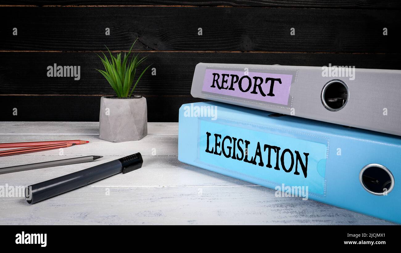 Gesetzgebung und Bericht. Dokumentenmappen, Ordner und Büromaterial auf einem Holzhintergrund. Stockfoto