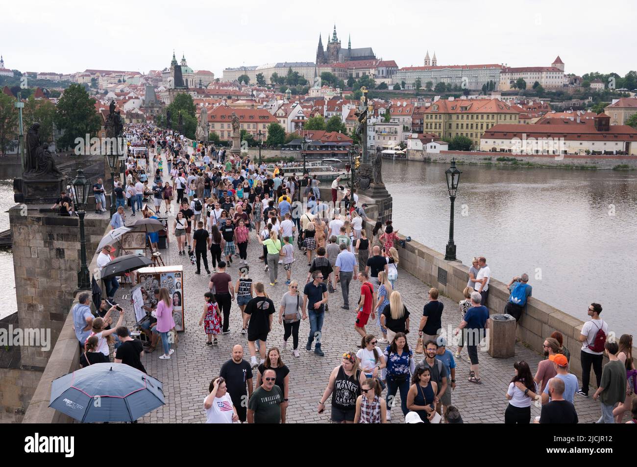 Prag, Tschechische Republik. 05.. Juni 2022. Passanten laufen über die Karlsbrücke vor der Prager Burg. Quelle: Sebastian Kahnert/dpa/Alamy Live News Stockfoto