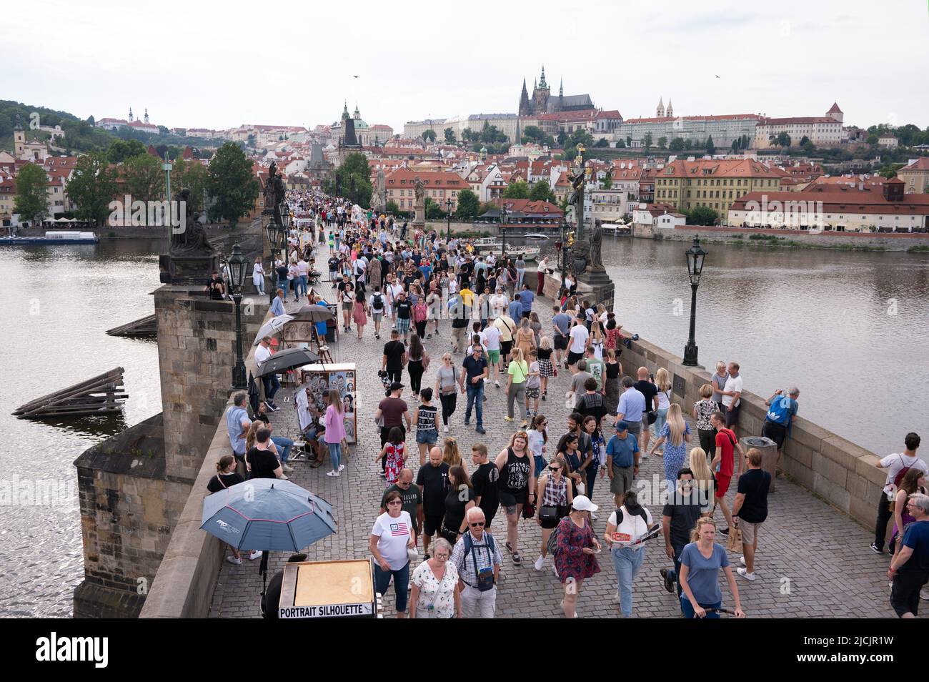 Prag, Tschechische Republik. 05.. Juni 2022. Passanten laufen über die Karlsbrücke vor der Prager Burg. Quelle: Sebastian Kahnert/dpa/Alamy Live News Stockfoto