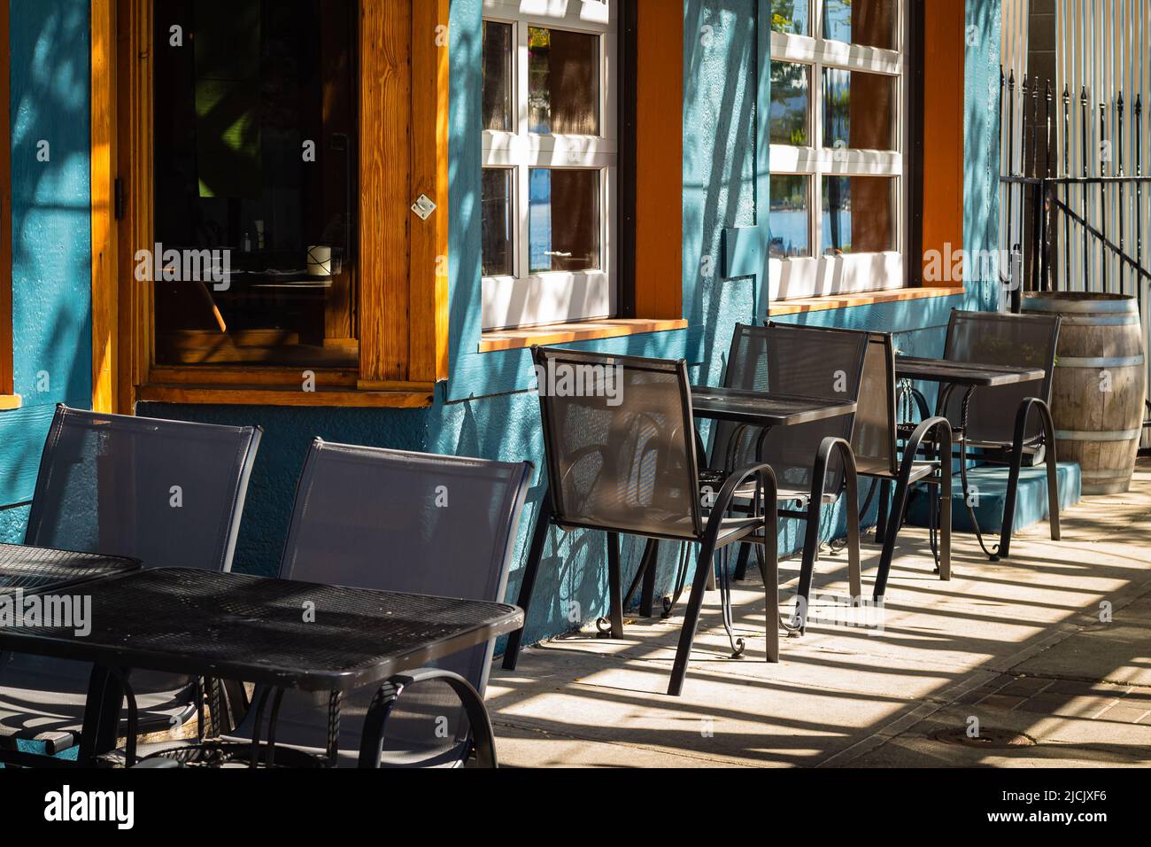 Leere Sommerterrasse des Restaurants mit Tischen und Stühlen. Café-Terrasse an der Fußgängerzone. Restauranttische, die auf Kunden im Freien warten Stockfoto