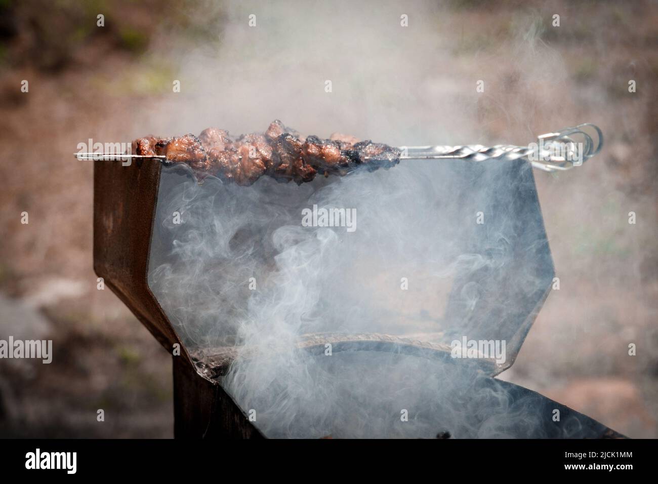 Lammfleisch auf Spießen wird auf dem Grill im Freien gebraten Stockfoto