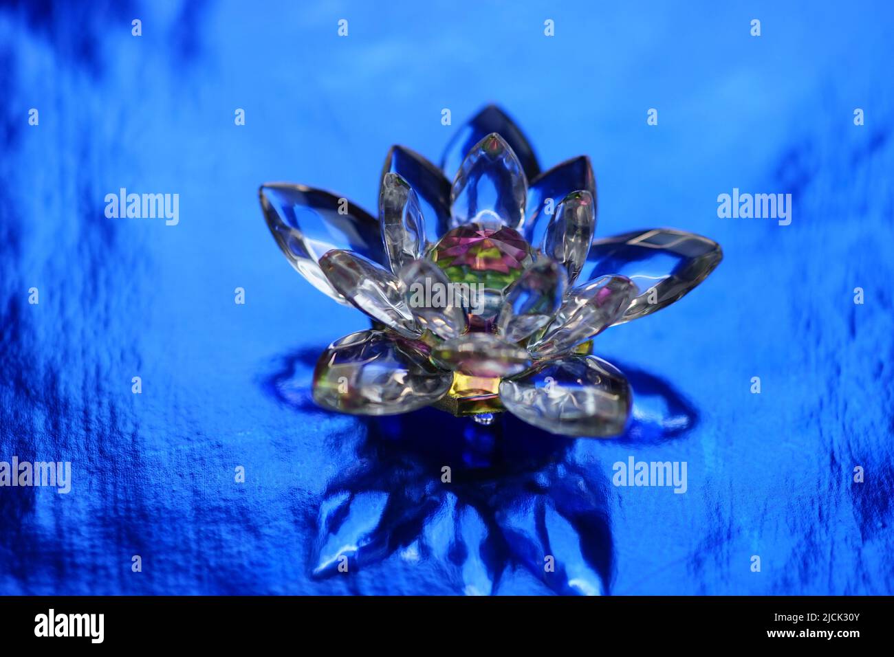 Kristalllotus auf einem dunkelblau glänzenden Tisch. Reiki-Meditation. Stockfoto