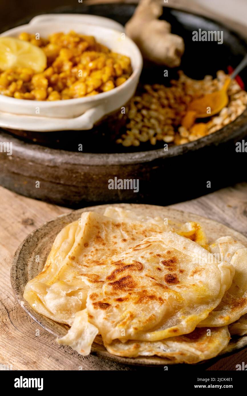Hausgemachtes Dhal mit Roti-Brot. Traditionelles indisches Gericht aus gelber Erbse mit Roti-Fladenbrot, serviert mit Zitrone in einer Keramikschale auf einem alten Holztisch. Stockfoto