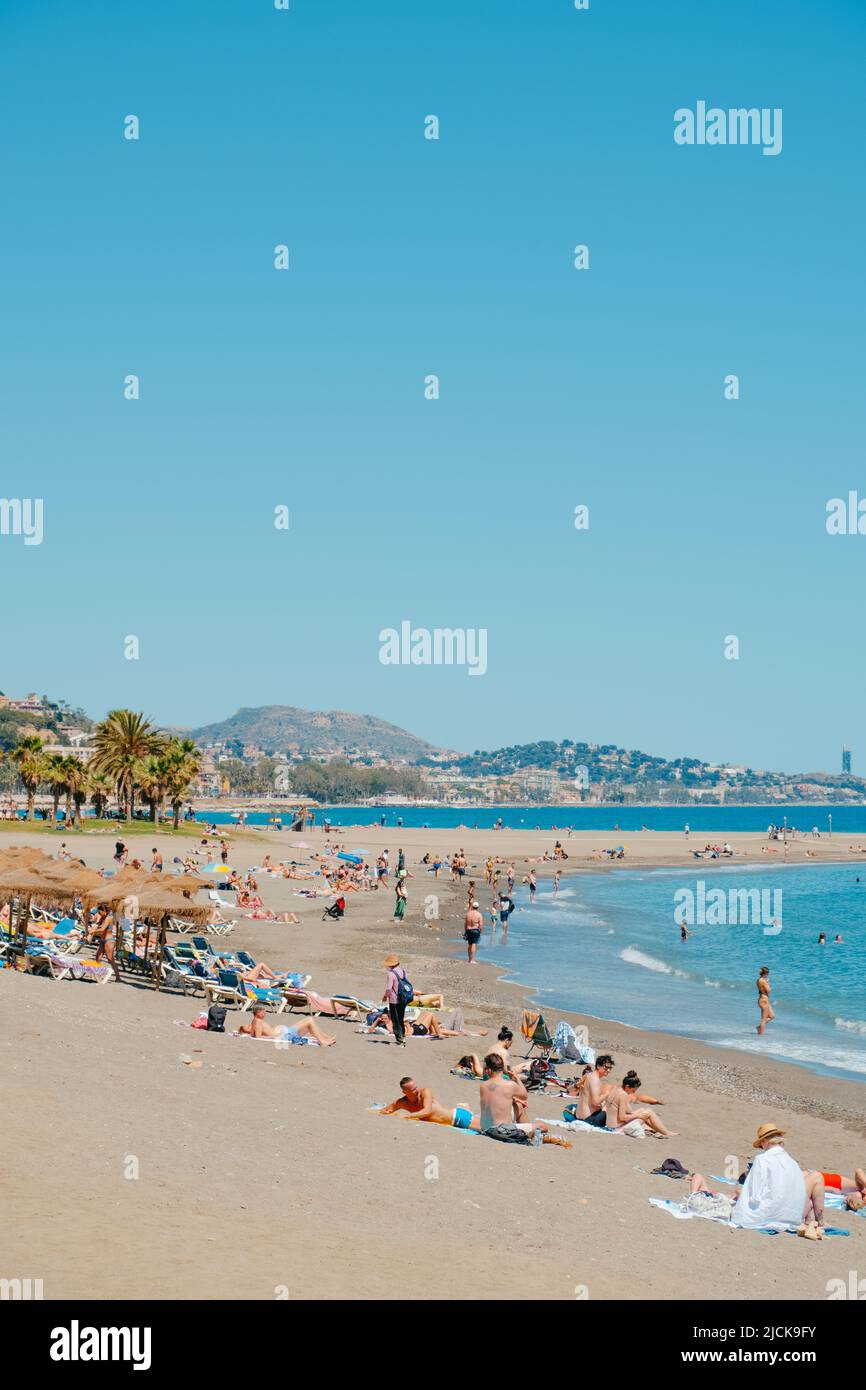 Malaga, Spanien - 26. Mai 2022: Menschen, die das gute Wetter eines sonnigen Frühlingstages am beliebten Strand La Malagueta in Malaga, Spanien, genießen Stockfoto