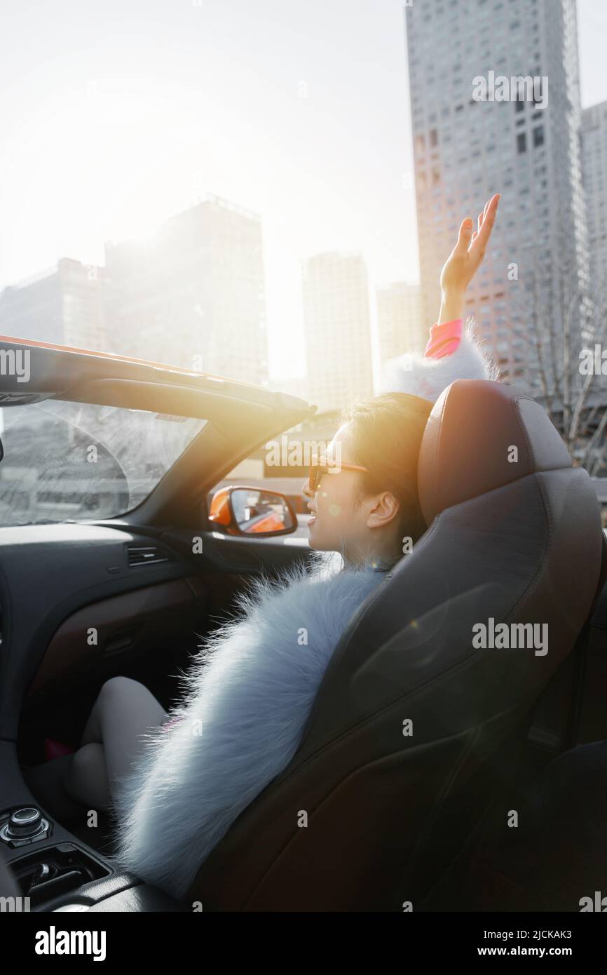 Die modische junge Frau, die im Co-Piloten sitzt, um eine Fahrt zu machen Stockfoto