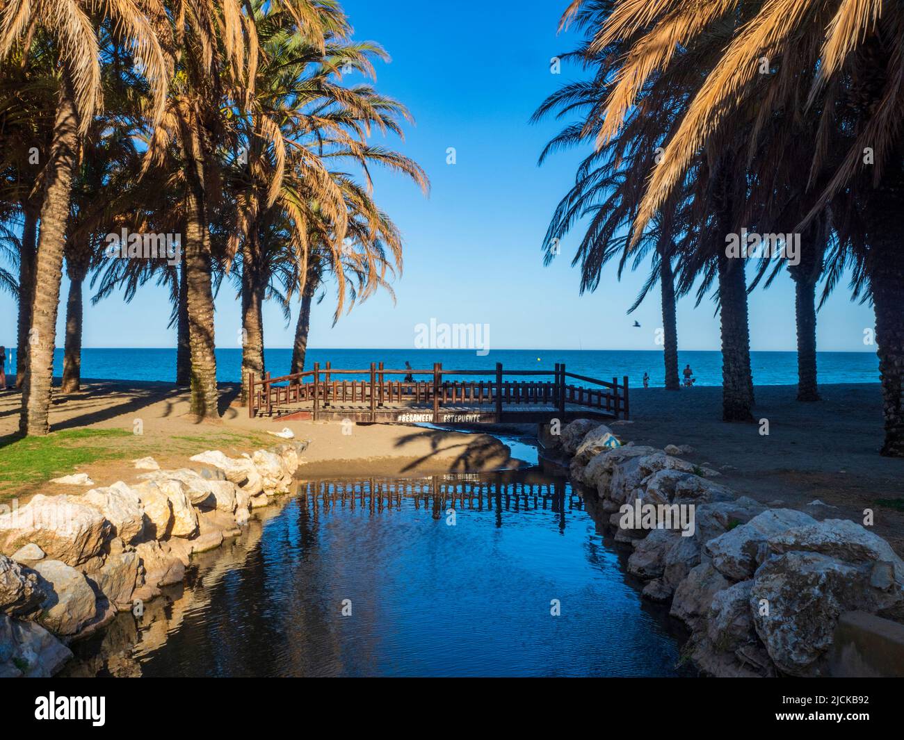 Holzbrücke zwischen Palmen vor dem Strand von Torremolinos Stockfoto