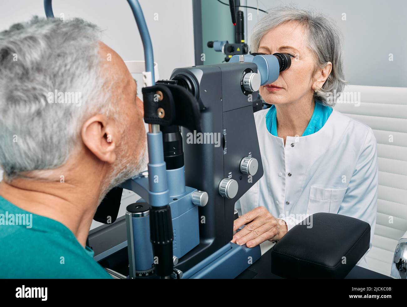 Leitender Mann, der Augenuntersuchung in der Augenklinik mit Optiker erhält. Augenheilkunde für ältere Menschen Stockfoto