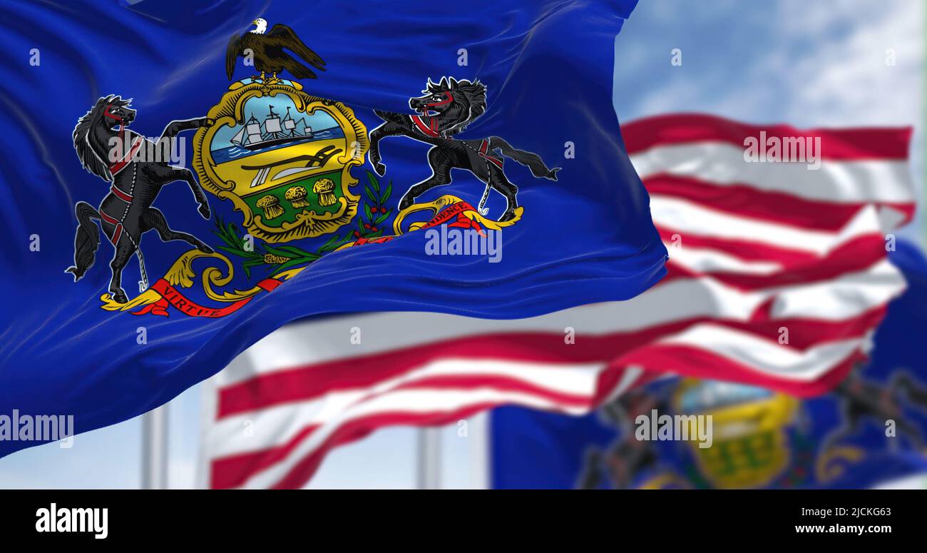 Die Staatsflagge von Pennsylvania winkt zusammen mit der Nationalflagge der Vereinigten Staaten von Amerika. Im Hintergrund ist der Himmel klar. Pennsylvania Stockfoto
