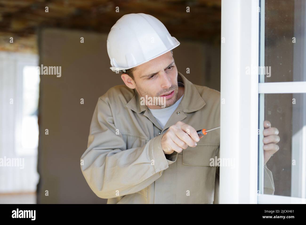 Fenstermontier mit Schraubendreher Stockfoto