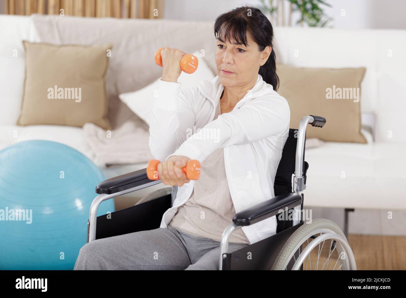 Eine behinderte Frau übt Dumpbells Stockfoto