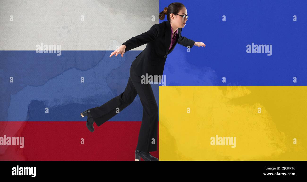 Asiatische Geschäftsfrau balanciert auf einem Fuß gegen russland und ukraine Flagge Design Hintergrund Stockfoto