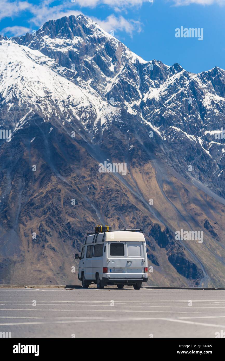Vertikale Aufnahme eines alten Transporters im Hintergrund des Kaukasus-Gebirges, Kazbegi, Georgien. Hochwertige Fotos Stockfoto