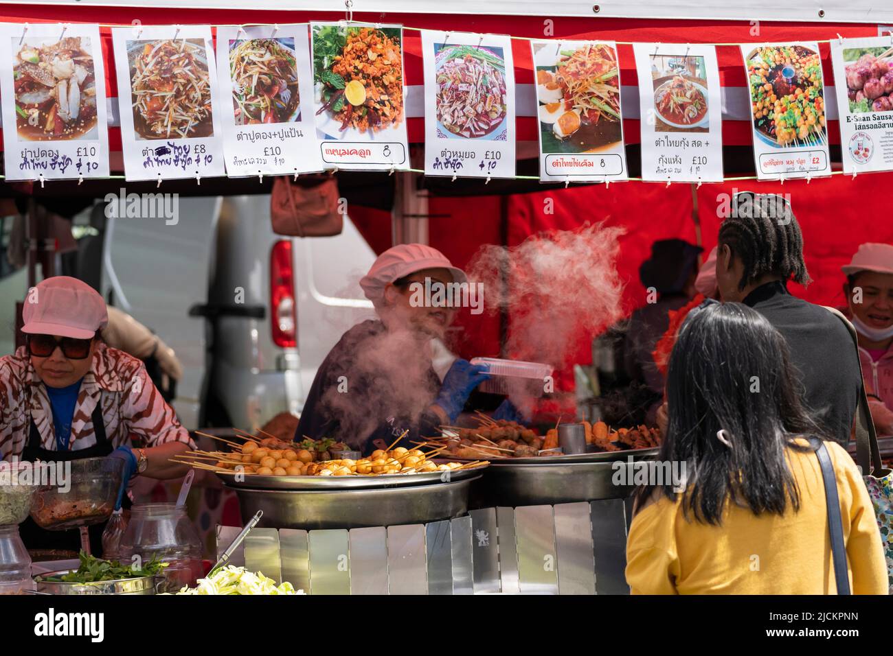 Ein Koch, der Thai-Essen an einem Fast-Food-Stand beim Magic of Thailand Festival im Basingstoke war Memorial Park serviert. Juni 12. 2022. England Stockfoto