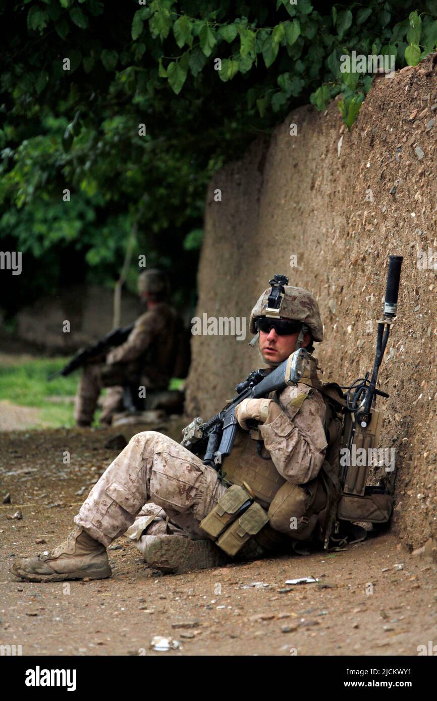 Eine US-Marine mit 1. Bataillon, 8. Marine Regiment (1/8), Regimental Combat Team 6, hält an und ruht während einer Patrouille im Dorf Payawak Stockfoto