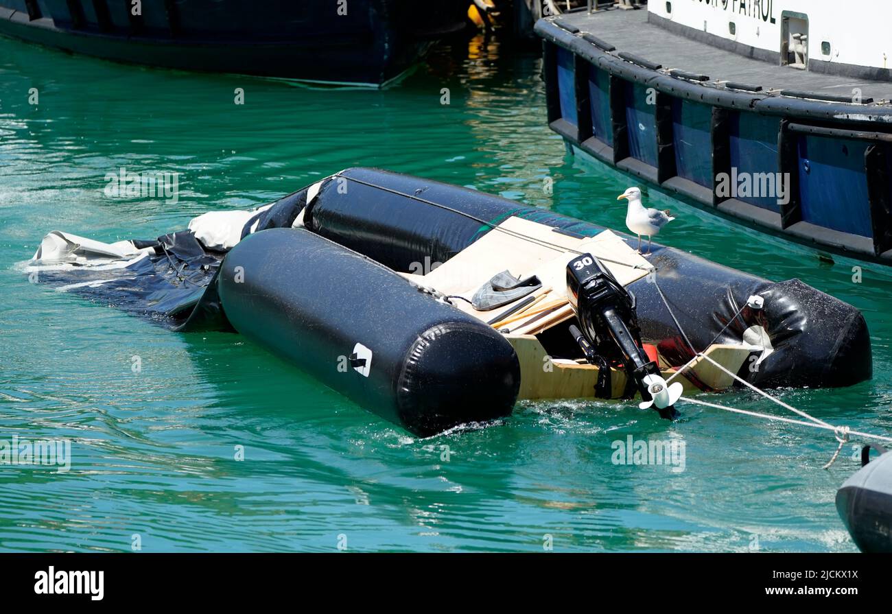 Ein teilweise untergetaucht aufblasbares Boot wird in die Marina gebracht, nachdem eine Gruppe von Menschen, die als Migranten gelten, nach einem Vorfall mit einem kleinen Boot im Kanal von der Border Force nach Dover, Kent, gebracht wurde. Bilddatum: Dienstag, 14. Juni 2022. Stockfoto