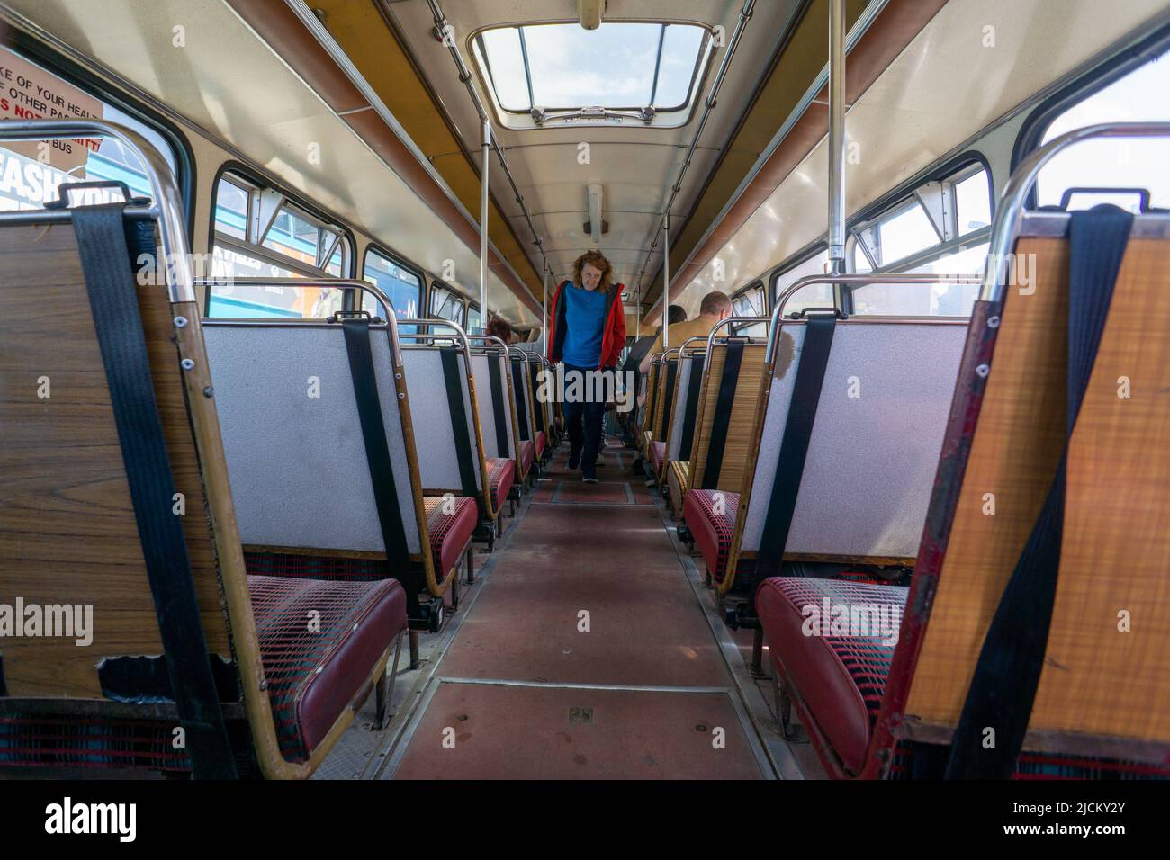 Person an Bord eines Oldtimer-Busses, der als Park fährt und von den Außenbezirken aus in eine Stadt fährt, um Verkehrsstaus und Luftverschmutzung zu vermeiden Stockfoto