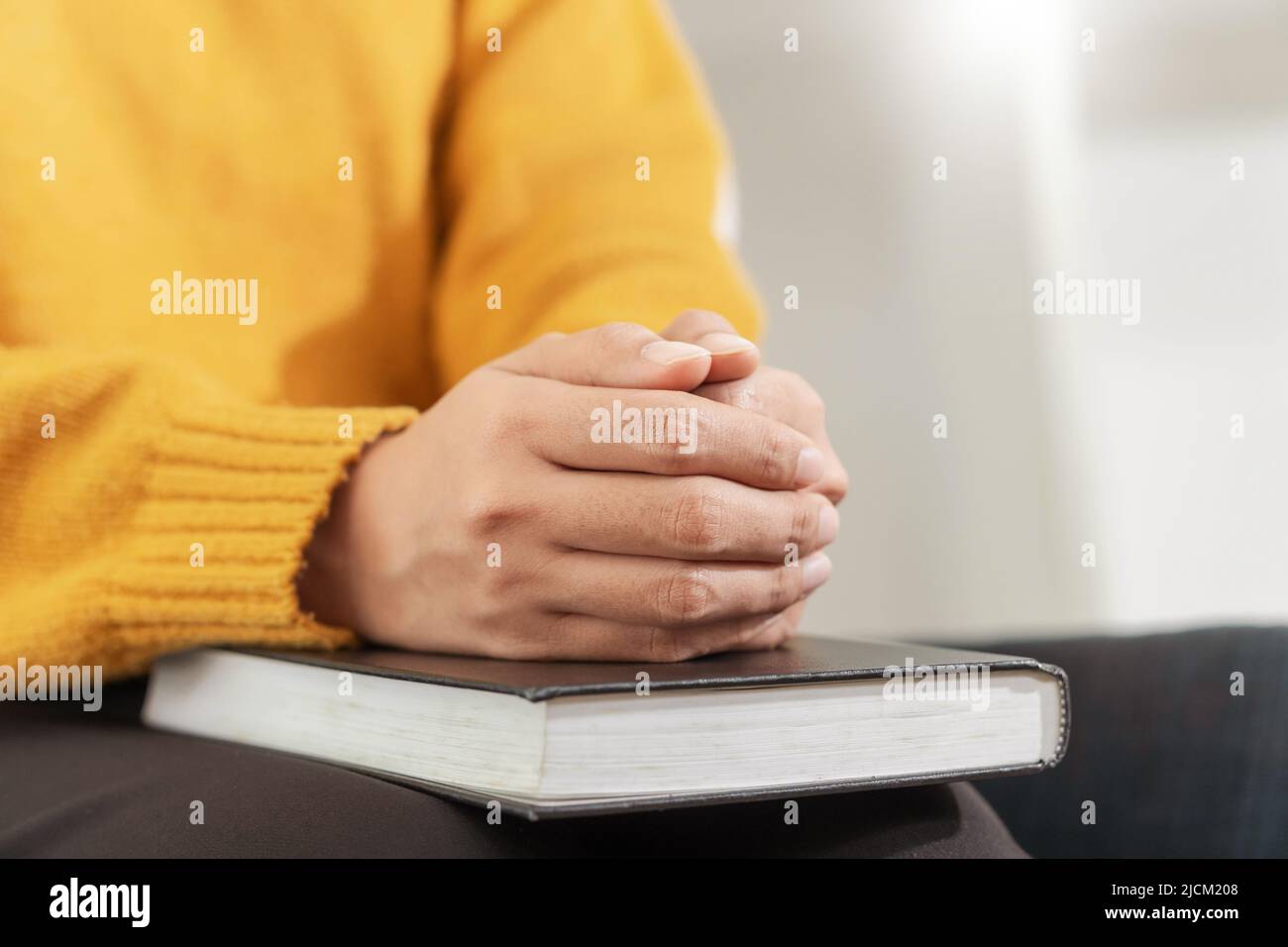 Beten und Religion Konzept, weibliche christliche Hände gefaltet auf der heiligen bibel und beten zu gott. Stockfoto