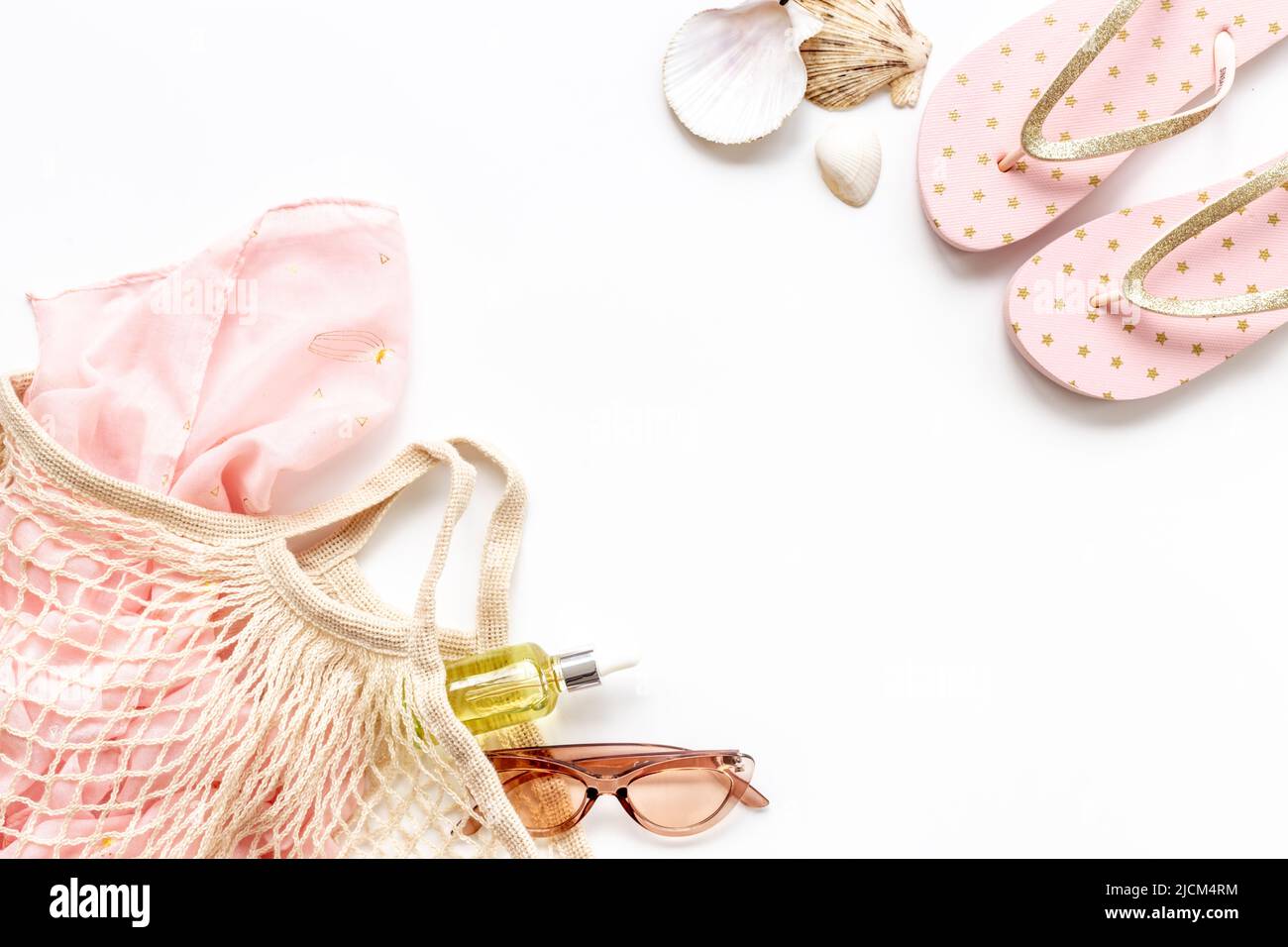 Sommerhintergrund mit Sonnenbrillen und Strandschuhen in Netzstringtasche Stockfoto