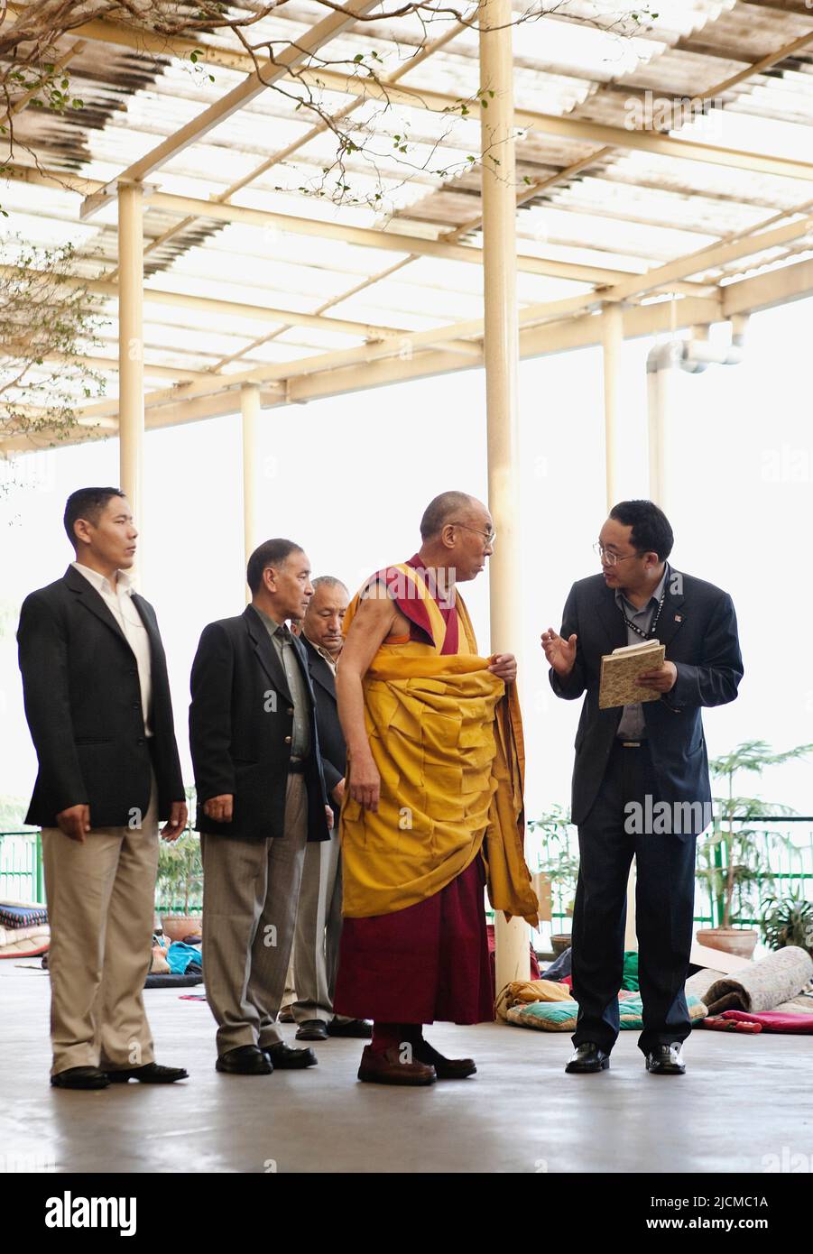 Umgeben von Sicherheit berät seine Heiligkeit der Dalai Lama vor einem Tag der Unterweisungen im Tsuglagkhang-Tempel mit seinem Sekretär. Stockfoto