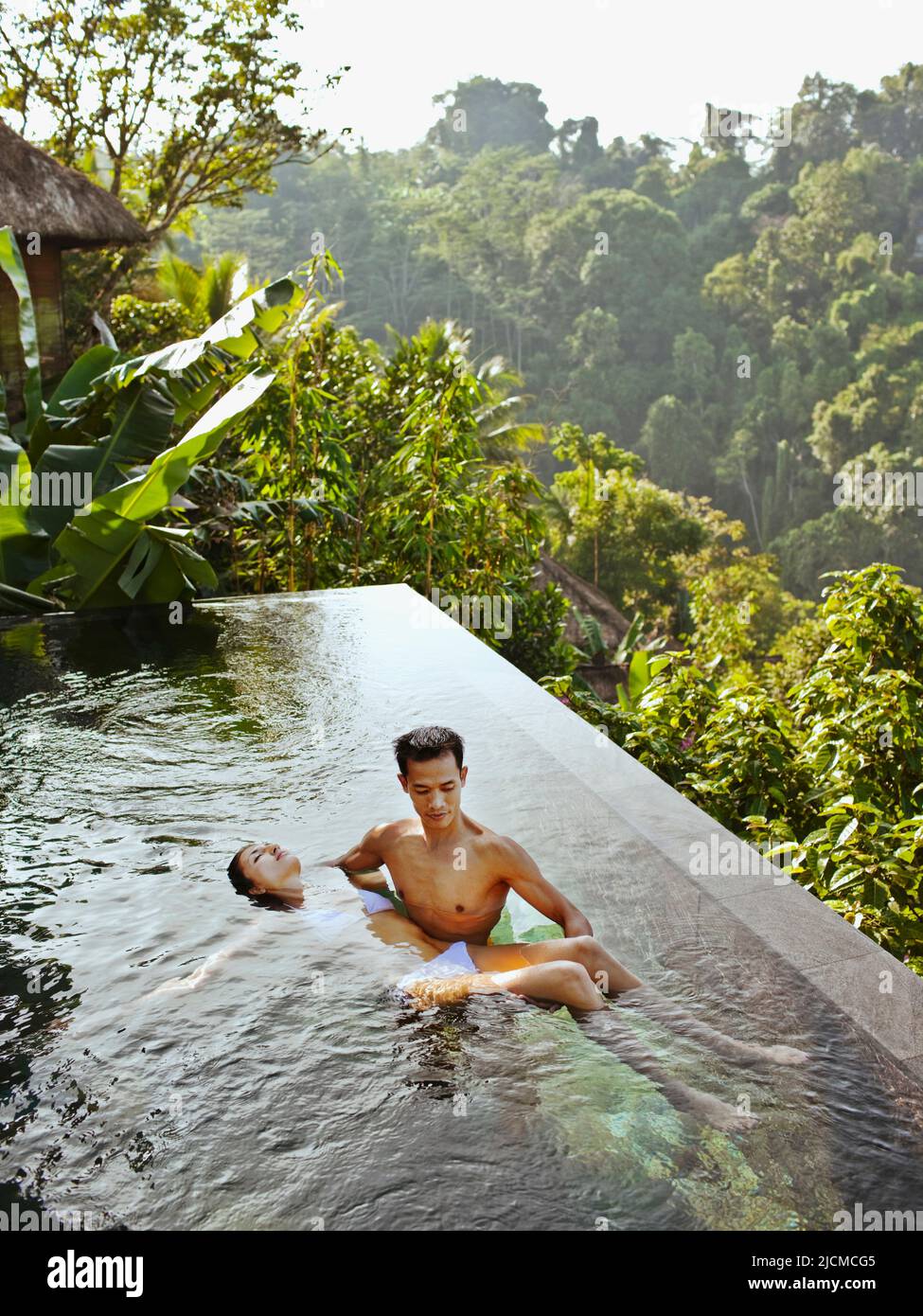 Eine Frau erhält eine Watsu-Behandlung im Überlaufpool einer privaten Pool-Villa in Ubud Hanging Gardens, Bali, Indonesien. Stockfoto