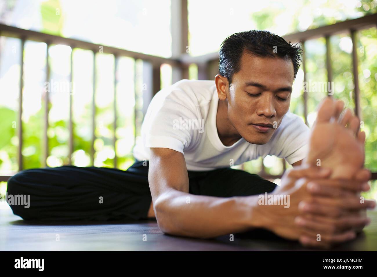 Junger Balinese praktiziert Yoga im Open-Air-Yoga-Pavillon in den Ubud Hanging Gardens, Bali, Indonesien. Stockfoto