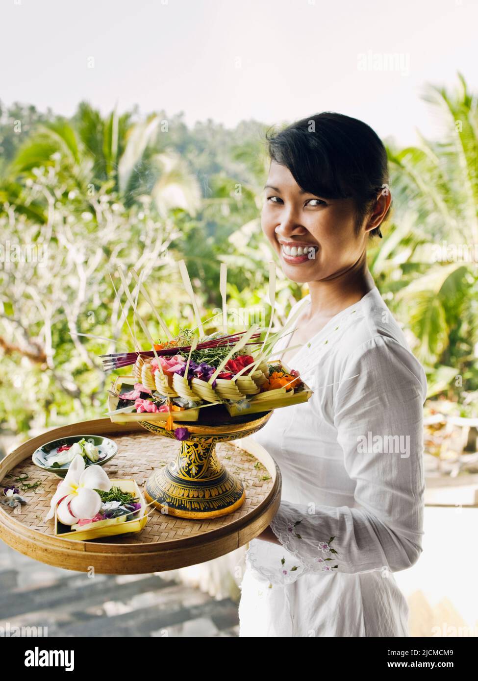 Balinesische Frau, die in den Ubud Hanging Gardens, Bali, Indonesien, Morgenangebote macht. Die Balinesen bieten den Spirituosen täglich Morgenangebote an. Stockfoto
