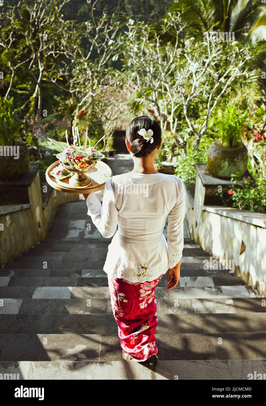 Balinesische Frau, die in den Ubud Hanging Gardens, Bali, Indonesien, Morgenangebote macht. Die Balinesen bieten den Spirituosen täglich Morgenangebote an. Stockfoto