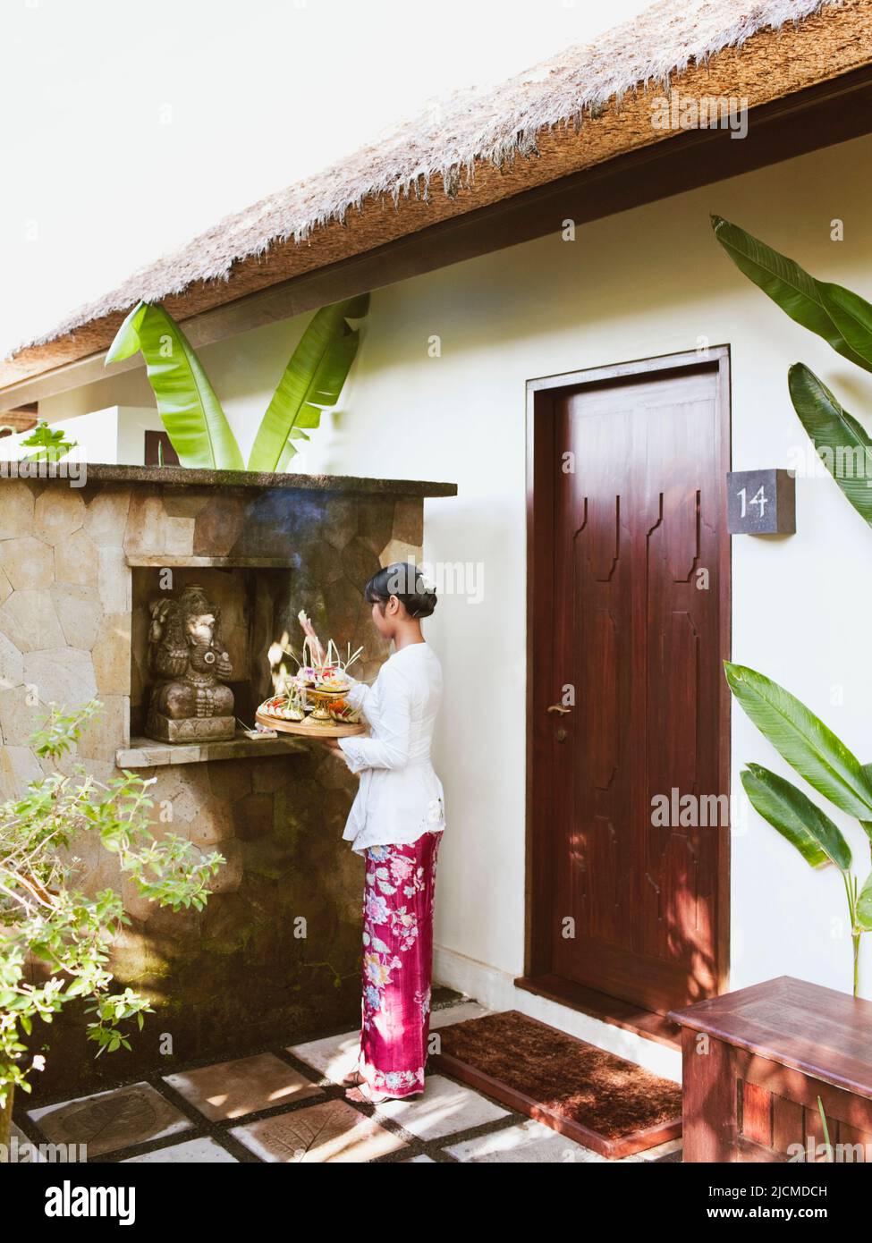 Balinesische Frau, die morgens dem Hindu-Gott Ganesh im Raum #14 in Ubud Hanging Gardens, Bali, Indonesien, anbietet. Die Balinesen machen morgens o Stockfoto