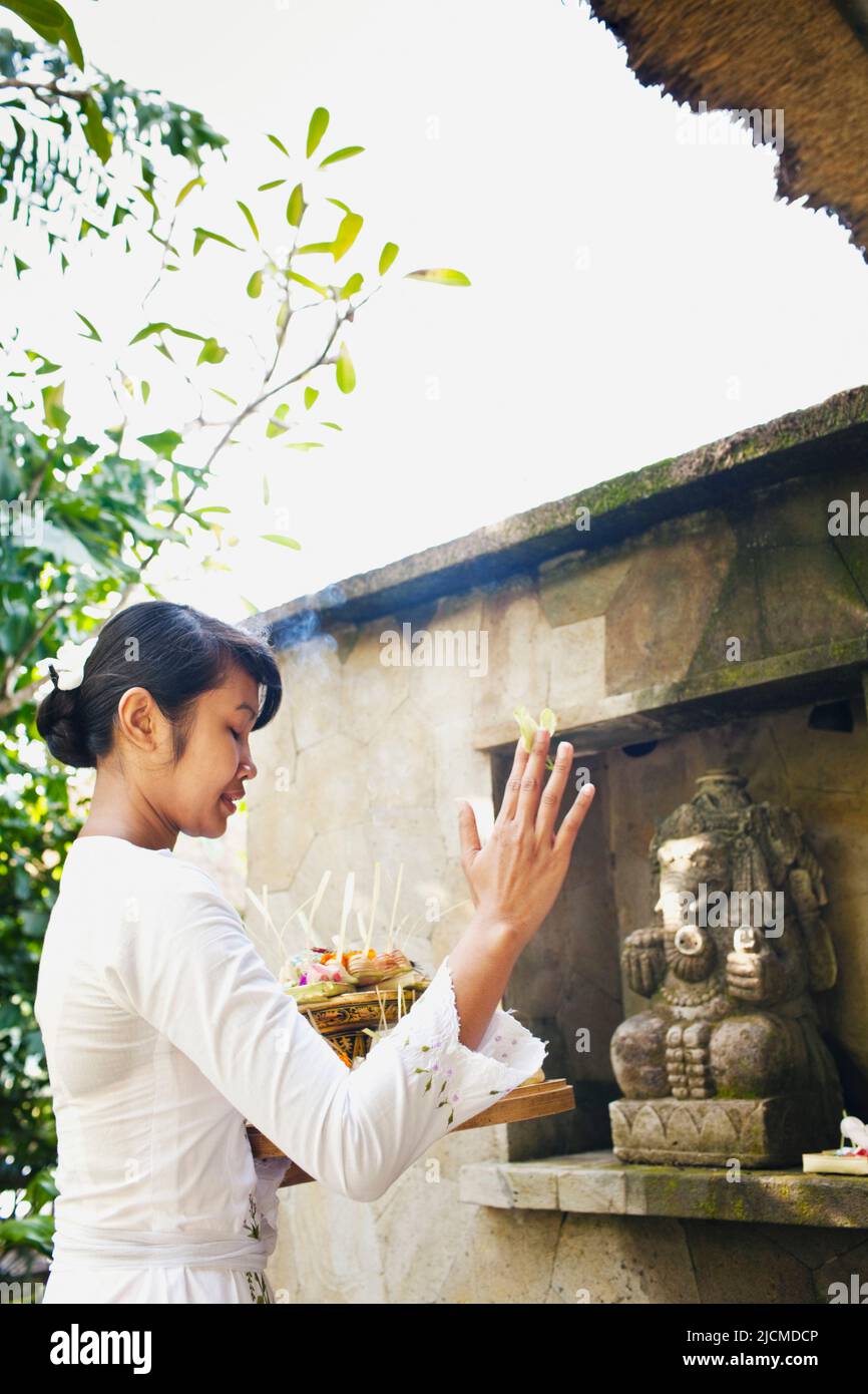 Balinesische Frau, die morgens dem Hindu-Gott Ganesh im Raum #14 in Ubud Hanging Gardens, Bali, Indonesien, anbietet. Die Balinesen machen morgens o Stockfoto