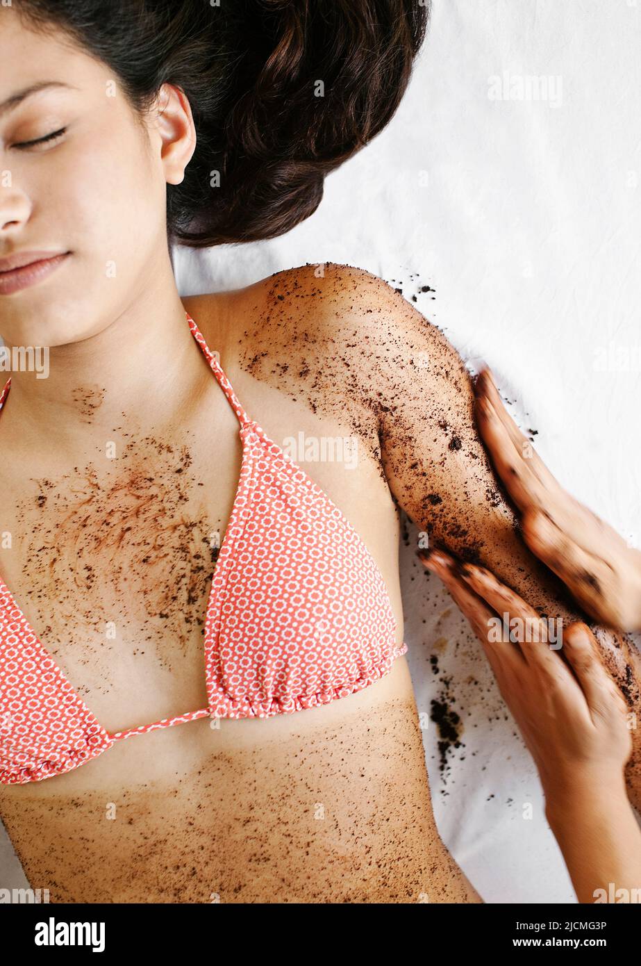 Frau Erhält Kaffeeschrubben. Thailand. Eine Frau erhält ein Kaffee-Körperpeeling im Freien in einer Cabana am Pool. Stockfoto