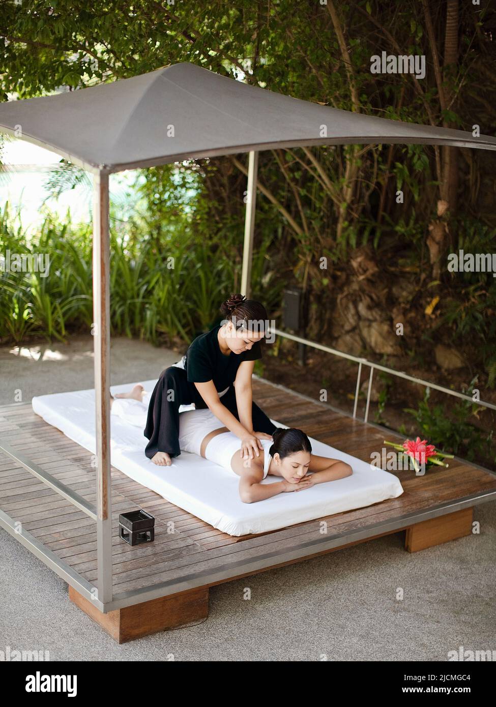 Eine Frau erhält eine Thai-Massage im Freien in einer Cabana am Pool. Phuket, Thailand. Stockfoto