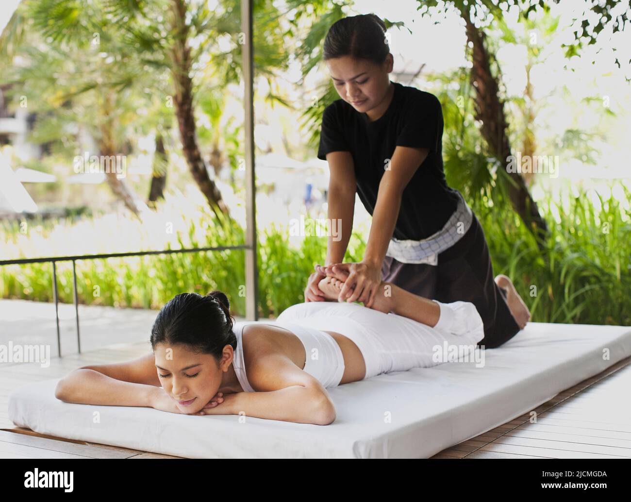Eine Frau erhält eine Thai-Massage im Freien in einer Cabana am Pool. Phuket, Thailand. Stockfoto