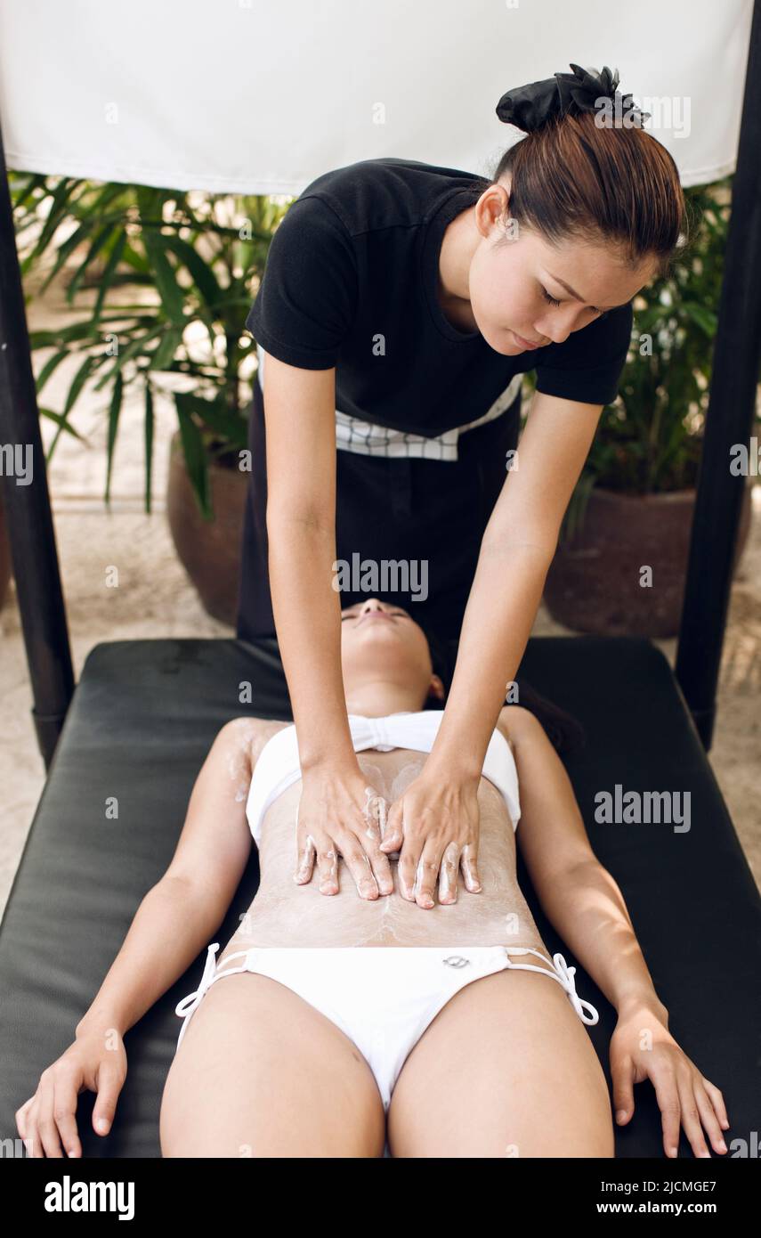 Frau, Die Körperpeeling Erhält, Phuket, Thailand. Eine Frau erhält ein thailändisches Reisschrubben an einer Strandhütte am Nai Yang Beach. Stockfoto