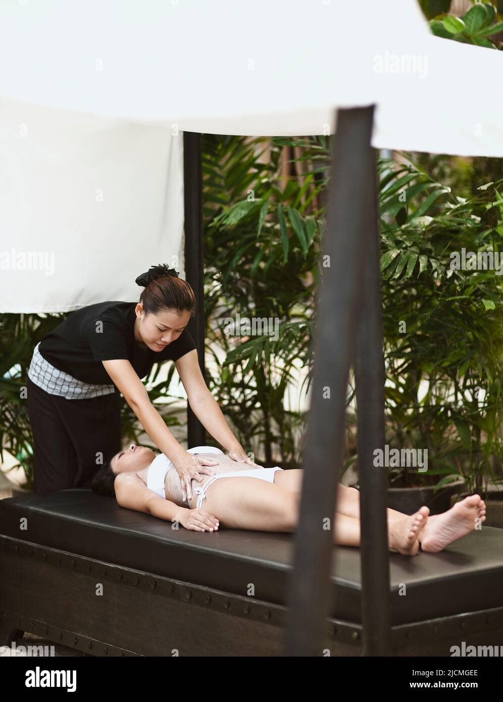 Frau, Die Körperpeeling Erhält, Phuket, Thailand. Eine Frau erhält ein thailändisches Reisschrubben an einer Strandhütte am Nai Yang Beach. Stockfoto