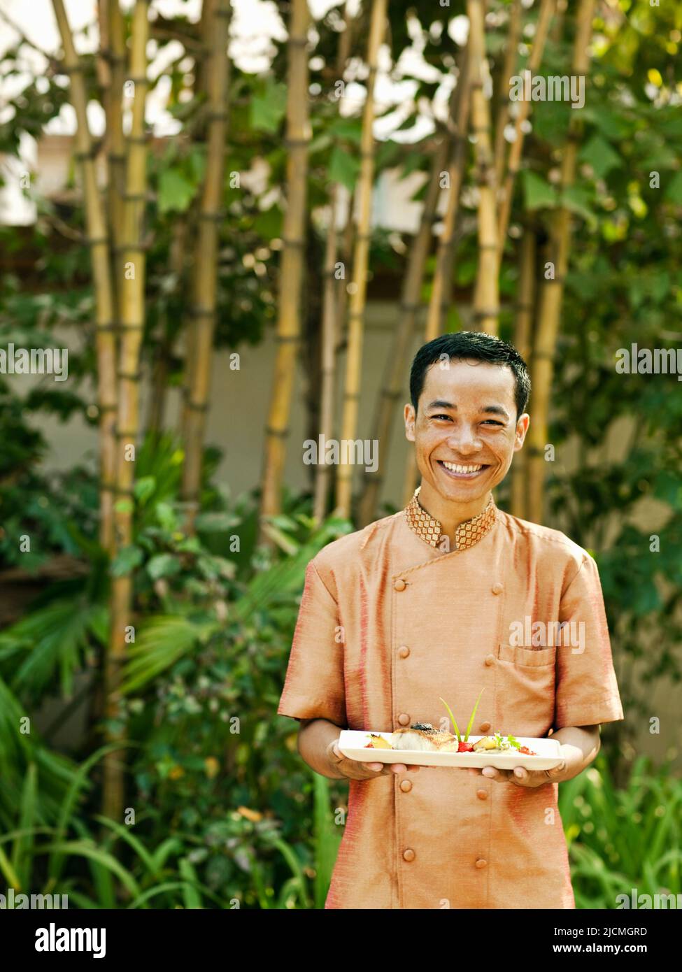 Ein asiatischer Kellner trägt Fischgerichte. Siem Reap, Kambodscha. Stockfoto