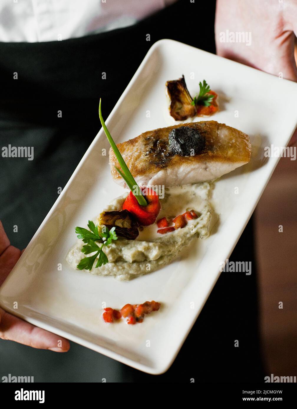 Geröstetes Seebarschfilet mit weicher olivfarbener Tapenade, Aubergine-Kaviar und Baby-Artischocken-Barigoule. Siem Reap, Kambodscha. Stockfoto