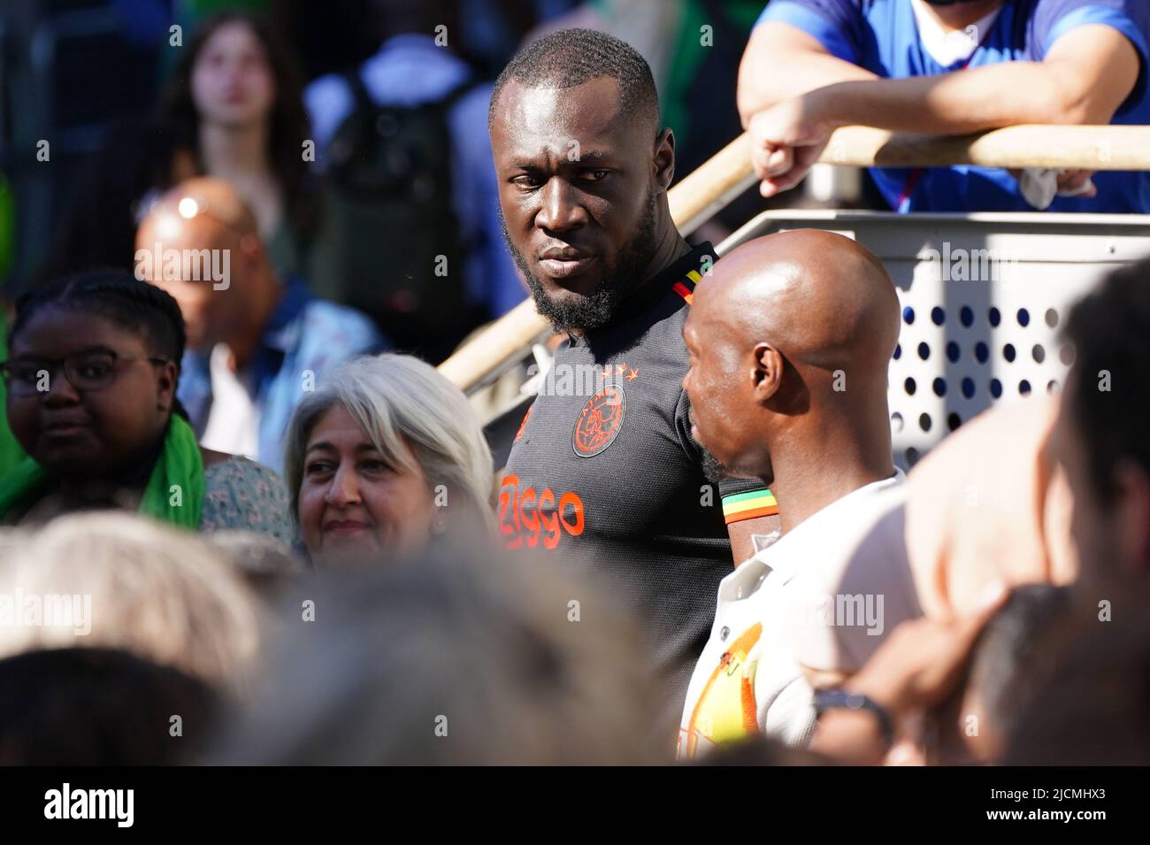 Stormzy beobachtet eine Zeremonie zur Festlegung von Glauben und Kranz auf einer großen Leinwand am Fuß des Grenfell Tower in London, in Gedenken an die Menschen, die am 14 2018. Juni beim Feuer im Grenfell Tower ums Leben kamen. Bilddatum: Dienstag, 14. Juni 2022. Stockfoto