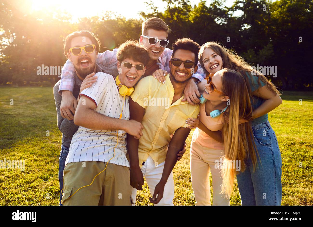 Eine Gruppe von glücklichen jungen multirassischen Freunden, die im Sommerpark herumhängen und Spaß haben Stockfoto