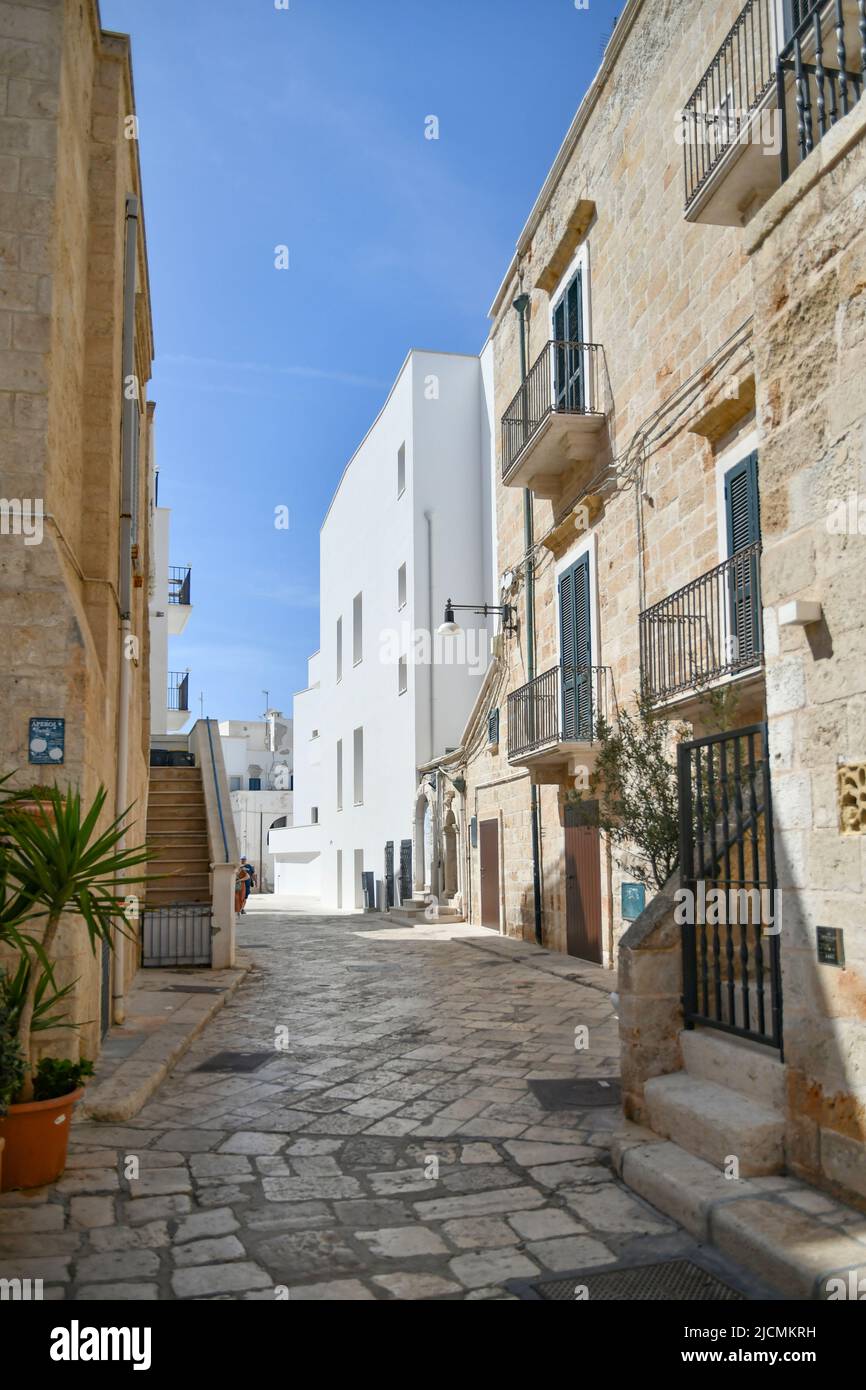 Eine kleine Straße zwischen den alten Häusern von Polignano a Mare. Mittelalterliche Stadt in der Region Apulien in Italien. Stockfoto