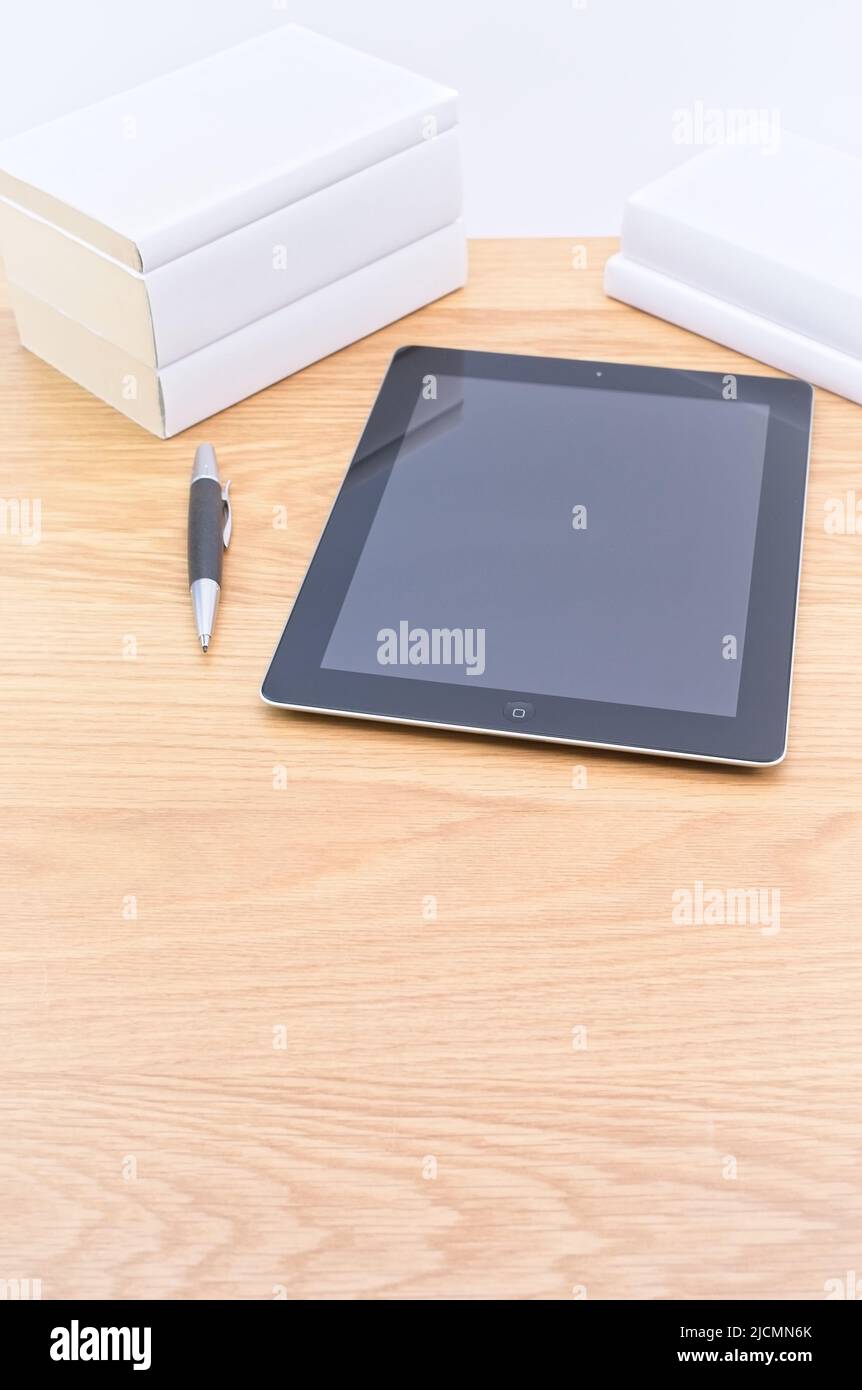 Apple ipad Tablet mit Bücher Stylus Stift auf einem hellen Holzschreibtisch an der weißen Wand Stockfoto