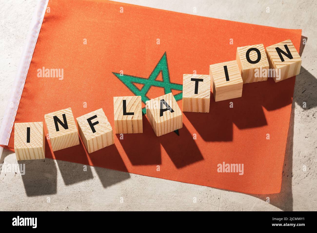 Flagge Marokkos und Holzwürfel mit Text, Konzept zum Thema Inflation im Land Stockfoto