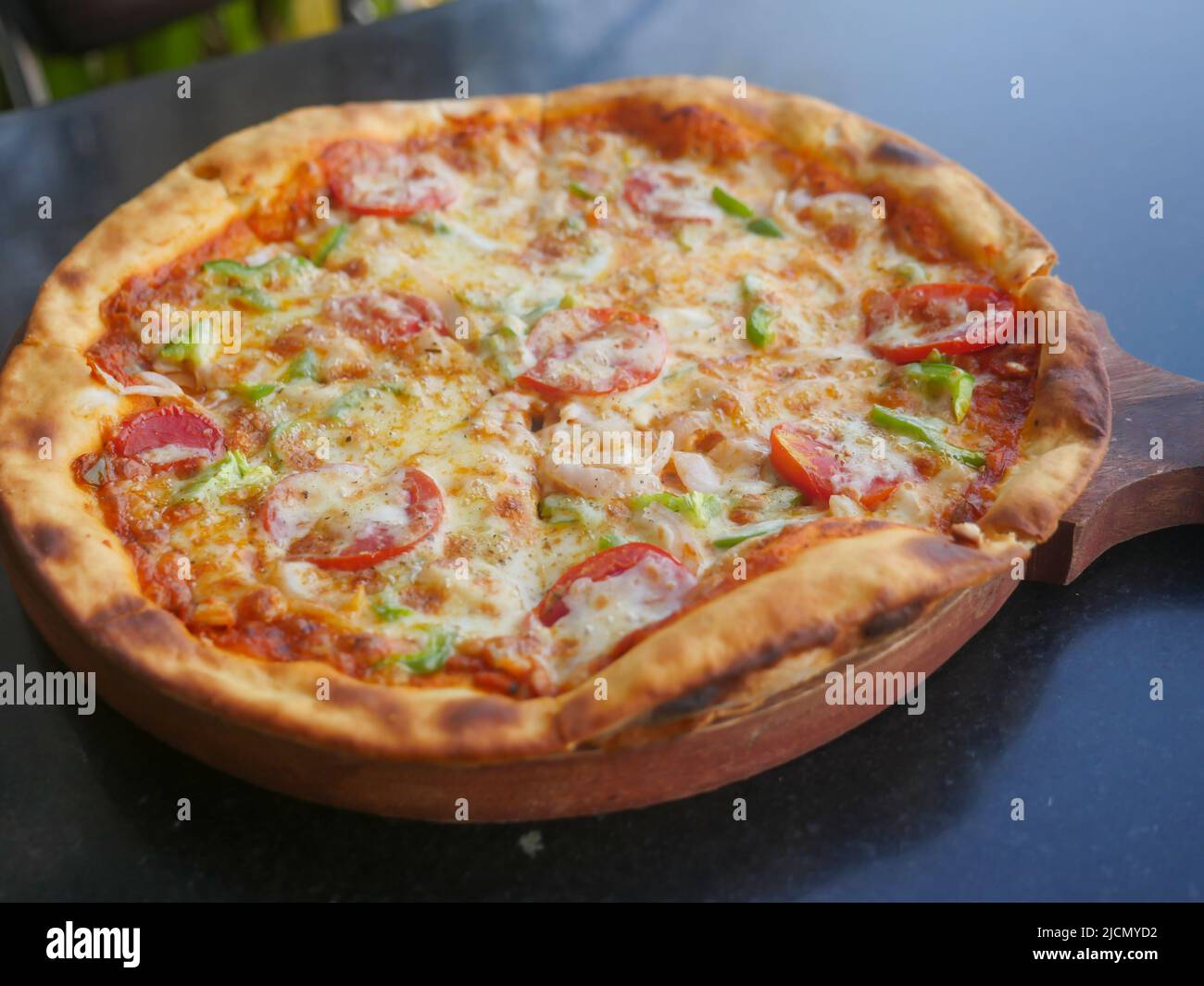 Indische vegetarische Käse Pizza mit Tomaten, Paprika und Zwiebeln gekrönt. Gemüse Pizza in indien Stockfoto