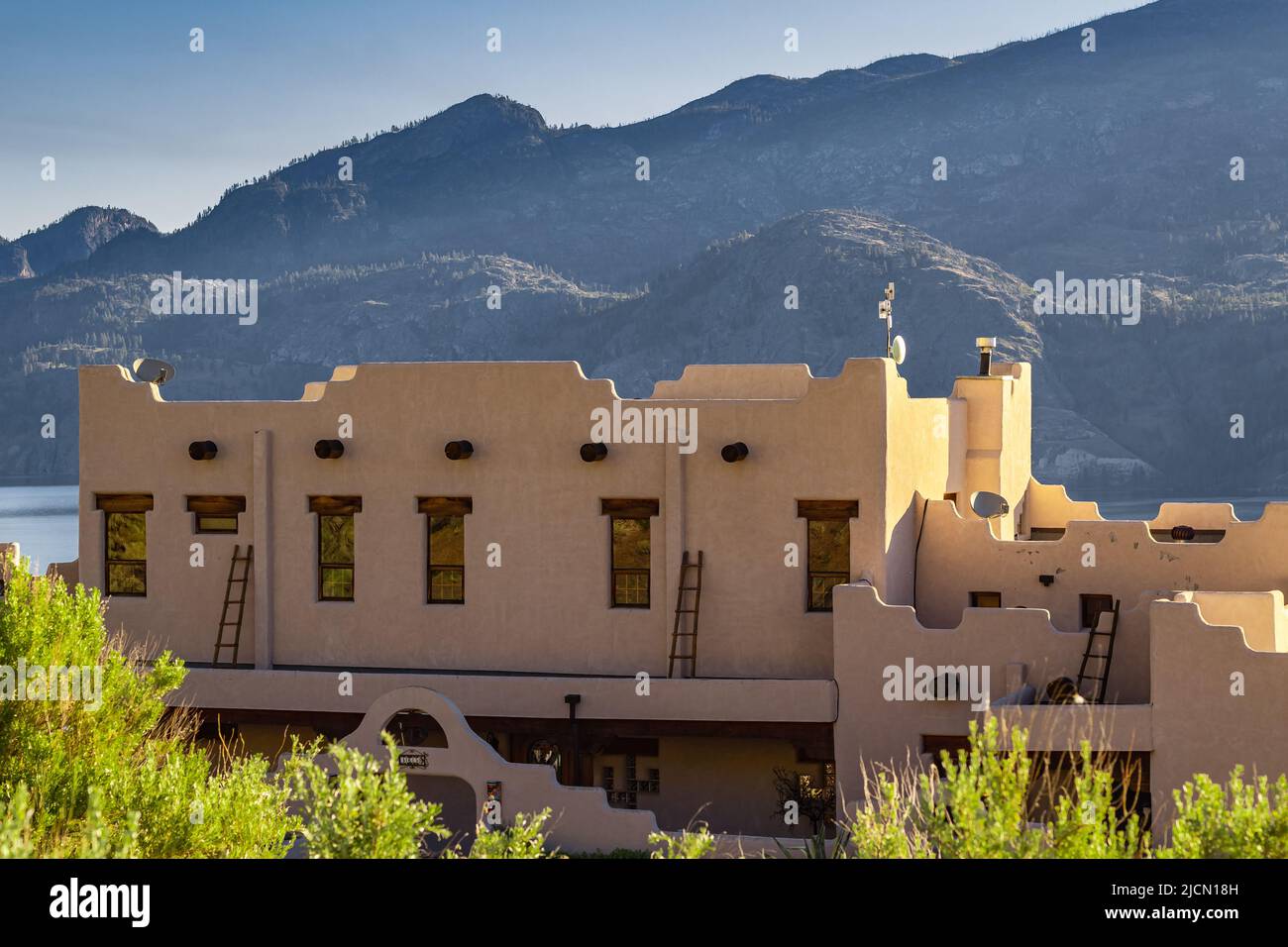 Wunderschöner Sonnenaufgang am Okanagan See. Ein schlossartes Haus am Morgen Sonnenlicht in den Bergen. Reisefoto, niemand, Platz für Text-Juni 7 Stockfoto