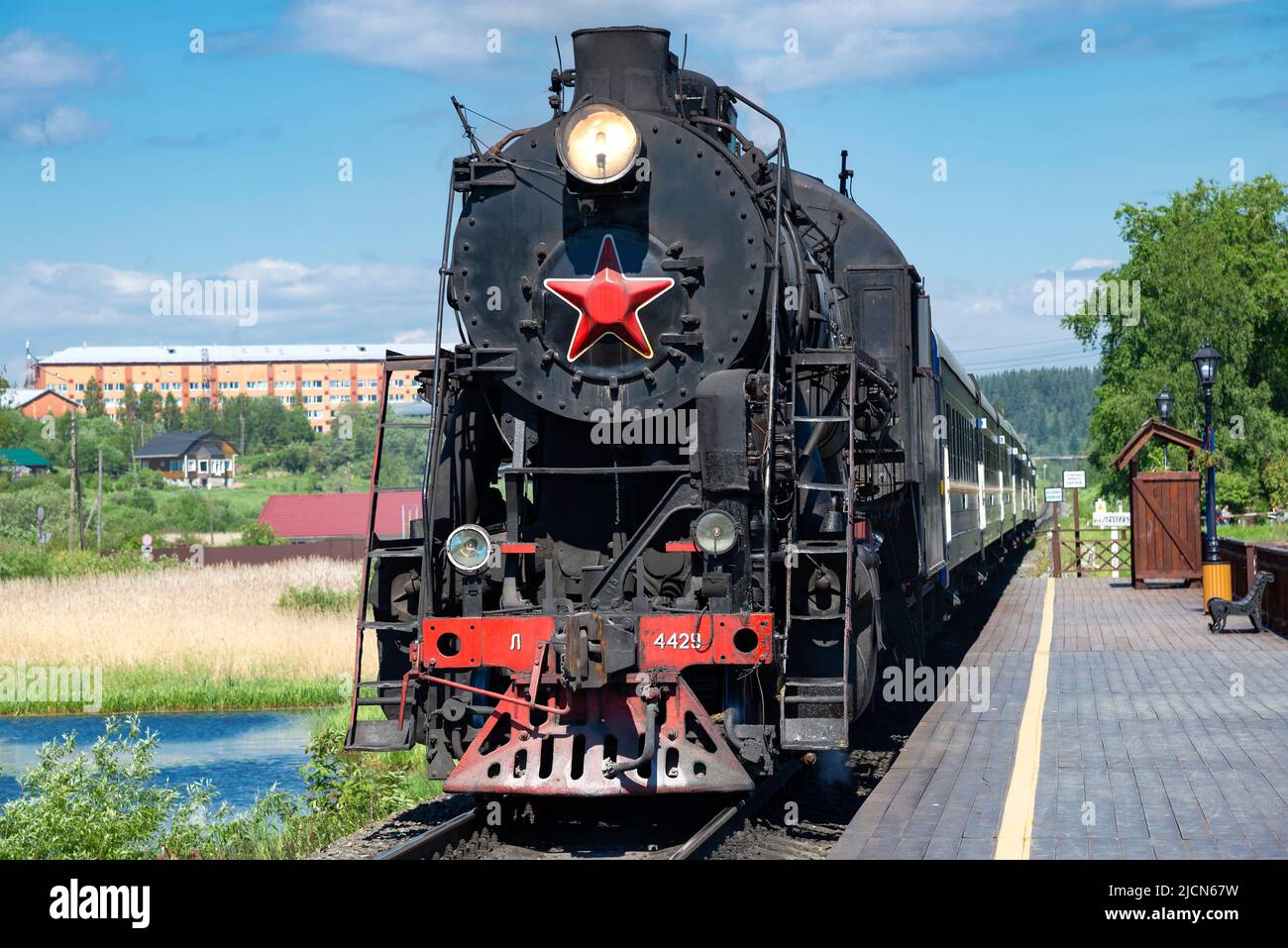 KARELIA, RUSSLAND - 11. JUNI 2022: Eine alte Dampflokomotive L-4429 mit einem Retro-Touristenzug 'Ruskealsky Express' am Bahnsteig des Bahnhofs. Karelien Stockfoto