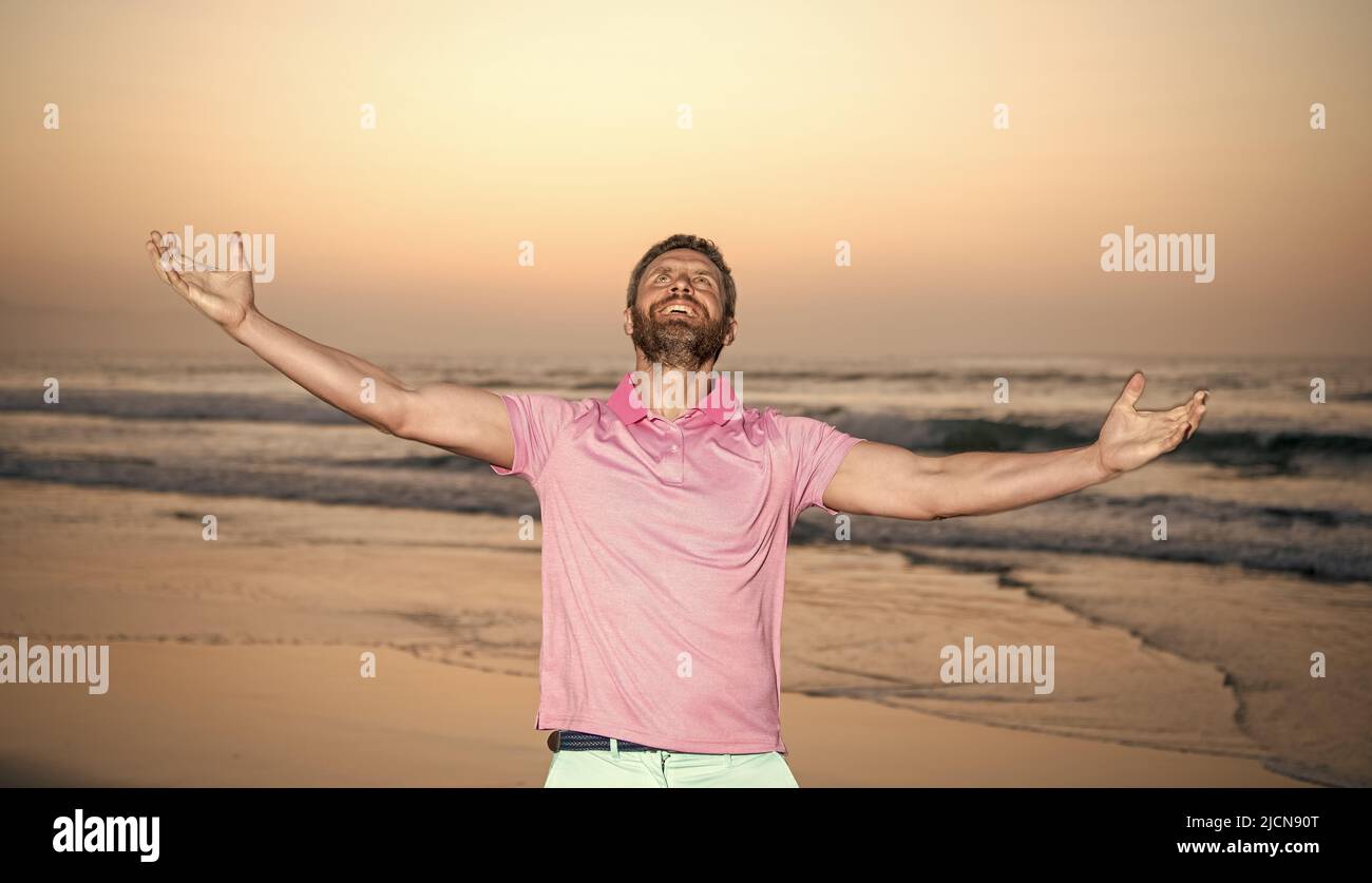 Glücklicher Mann über dem Meer fühlen Freiheit am Morgen Sommer Strand, Urlaub Stockfoto