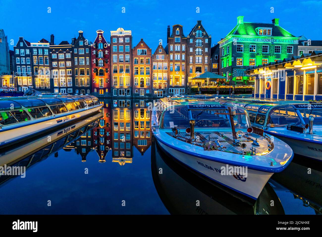 Kanalhäuser am Damrak, im Zentrum der Altstadt von Amsterdam, Hafen, Ausgangspunkt vieler Kanaltouren, Abend, Niederlande, Stockfoto